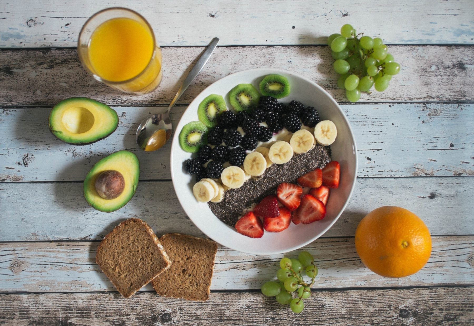 Frühstücksbowl mit Haferflocken, frischen Früchten und Nüssen, von oben fotografiert